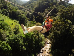 Person ziplining high above mountain valley