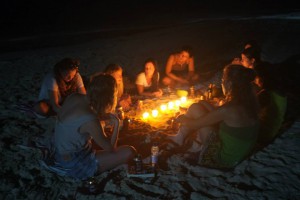 Students gathered around candles on beach