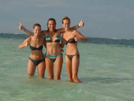 Three girls posing in clear caribbean water