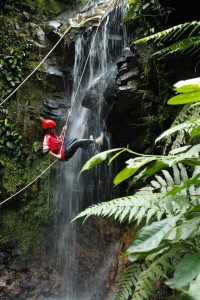 Person rappelling down a waterfall