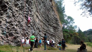 One person climbing and lots of people looking at the wall