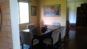 Dining table with chairs and painting on the wall.